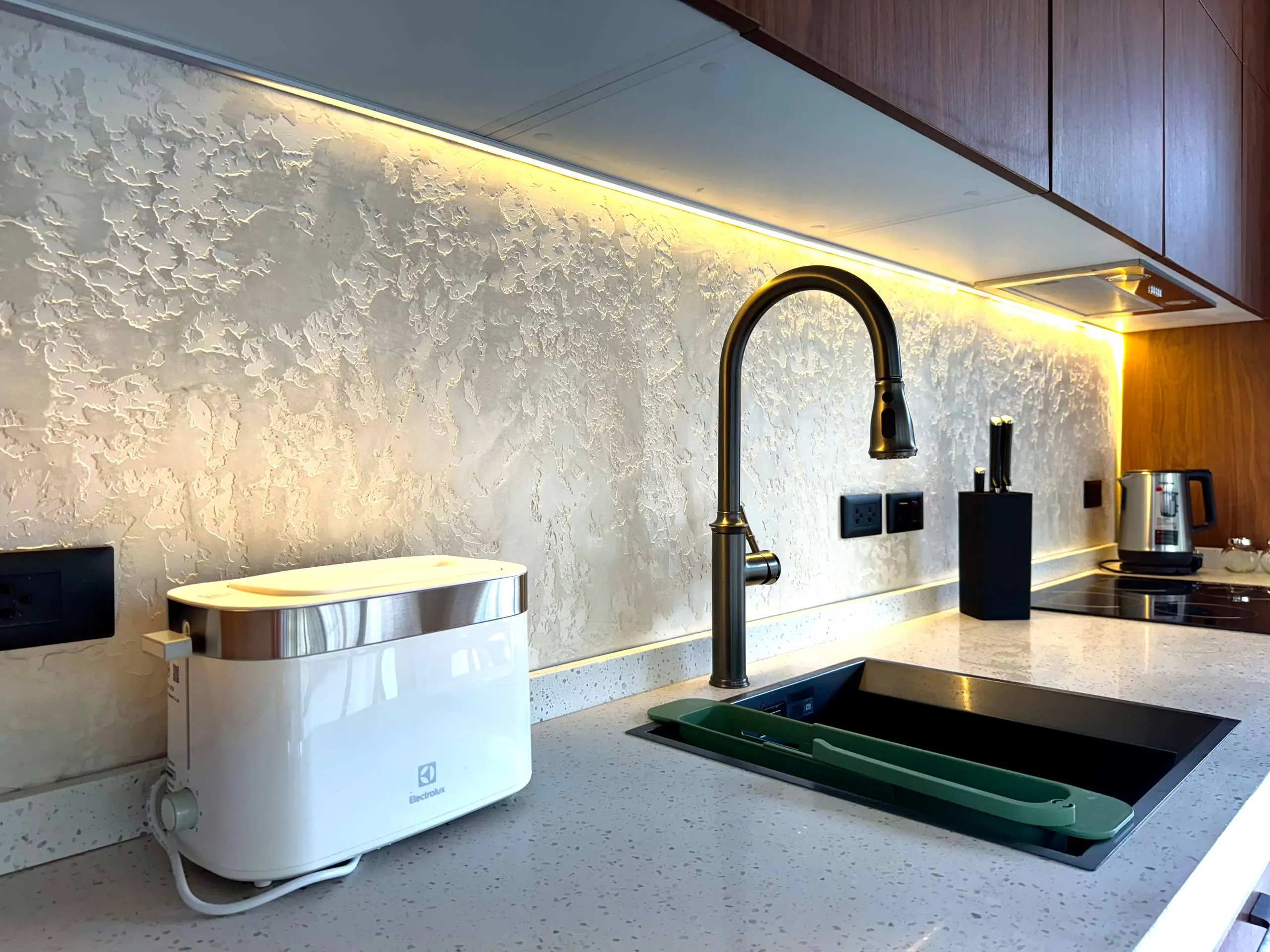 Villa I — kitchen counter with inset sink and warm backsplash lighting