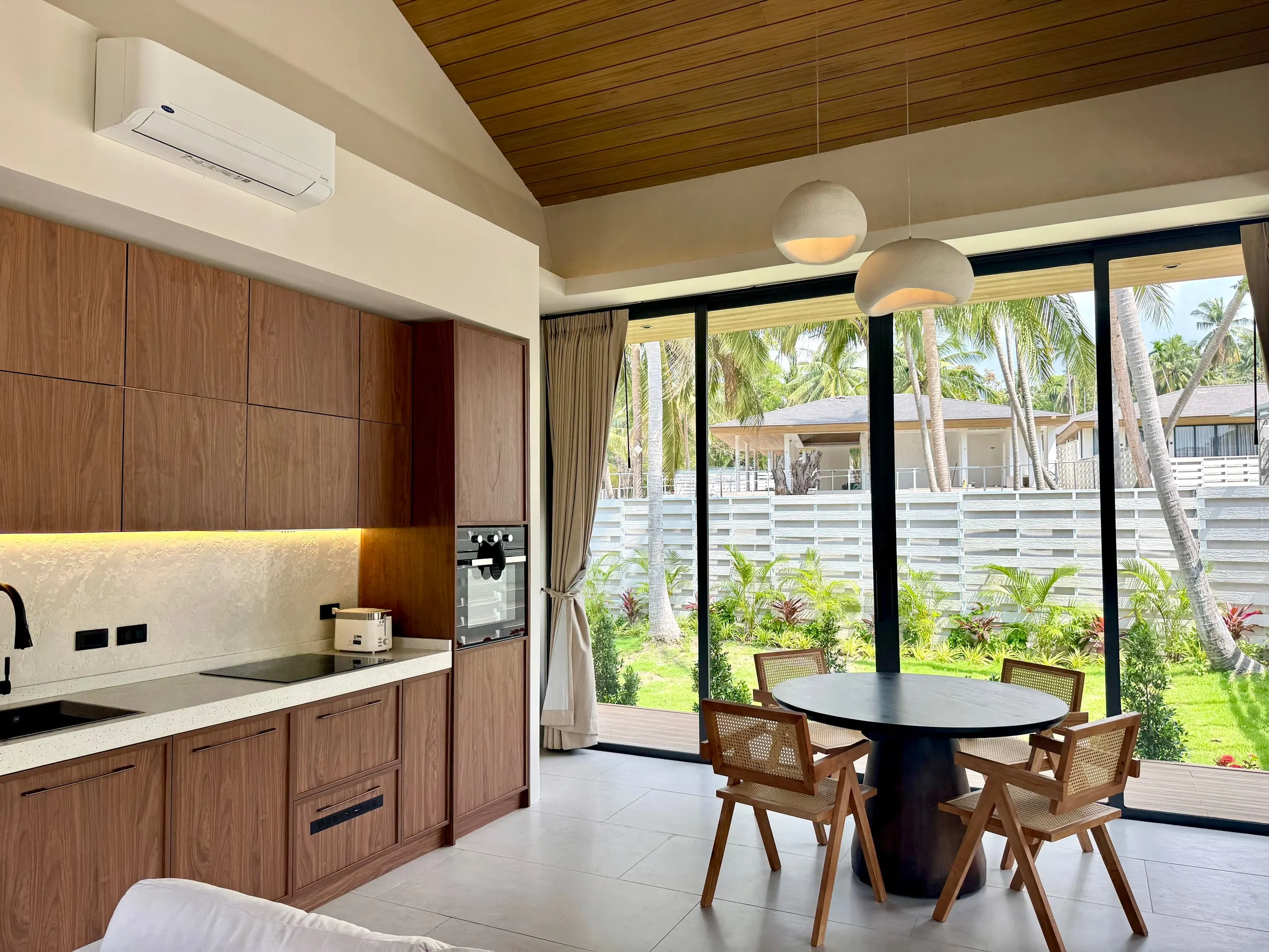 Villa I — kitchen-dining with a round black table and woven chairs