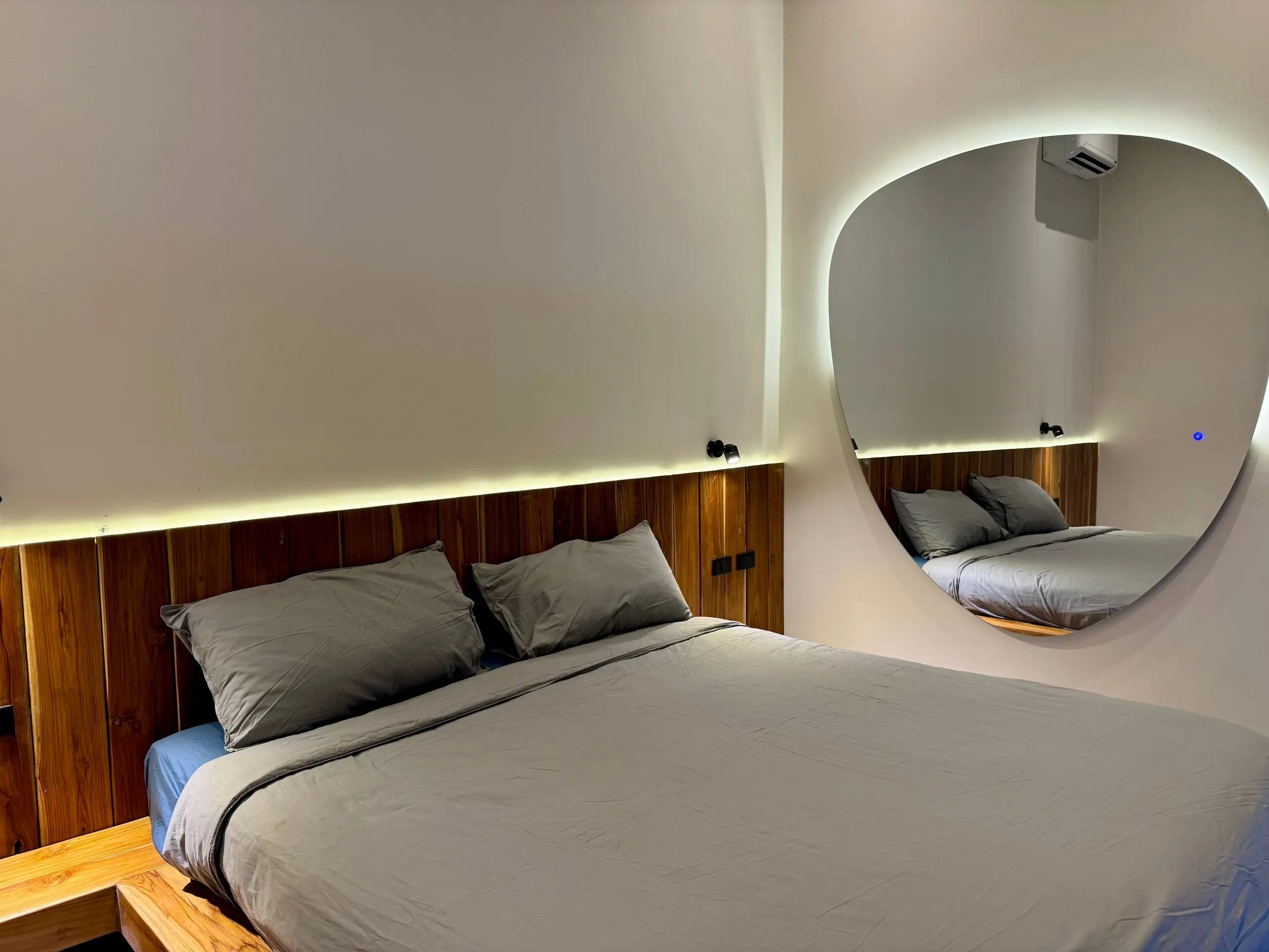 Villa I — bedroom two, platform bed and teardrop mirror
