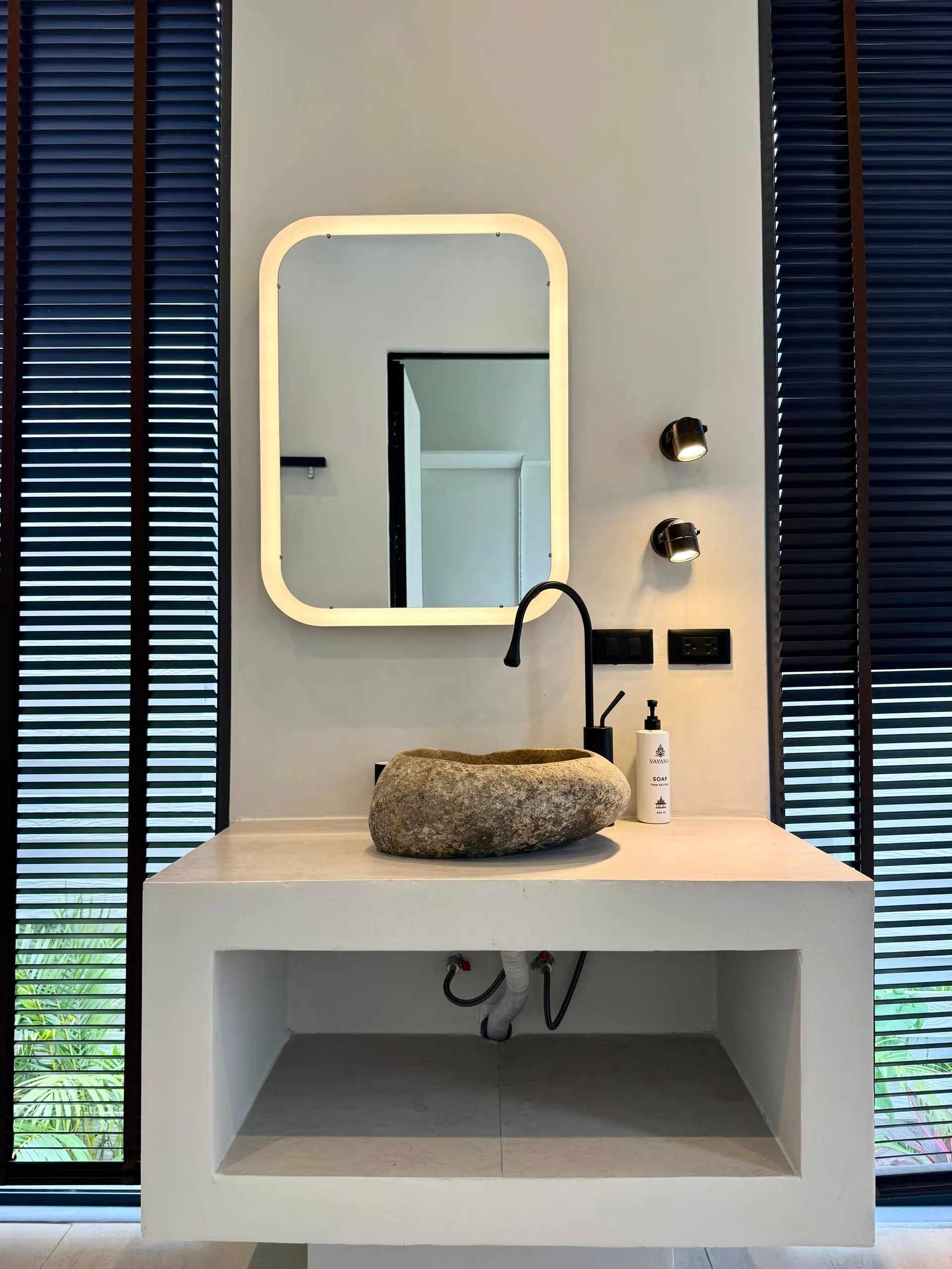 Villa I — boulder sink on a concrete vanity with lit mirror