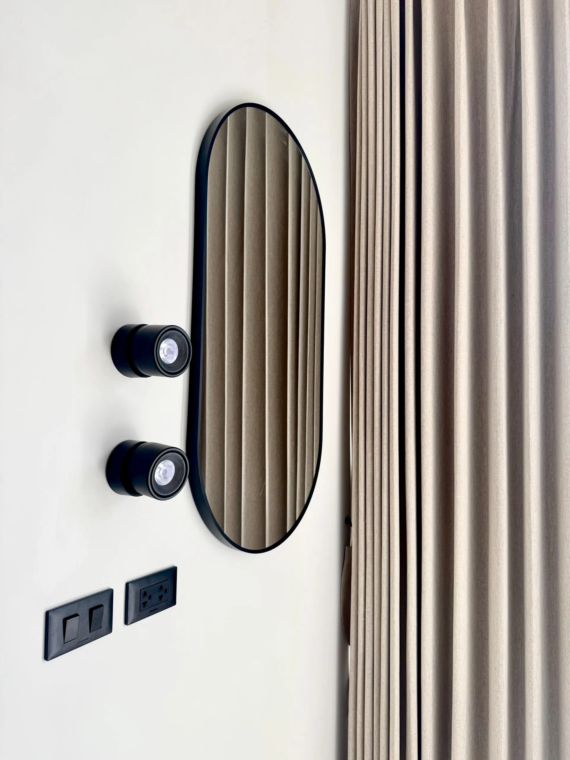 Villa II — oval mirror and black spotlights detail