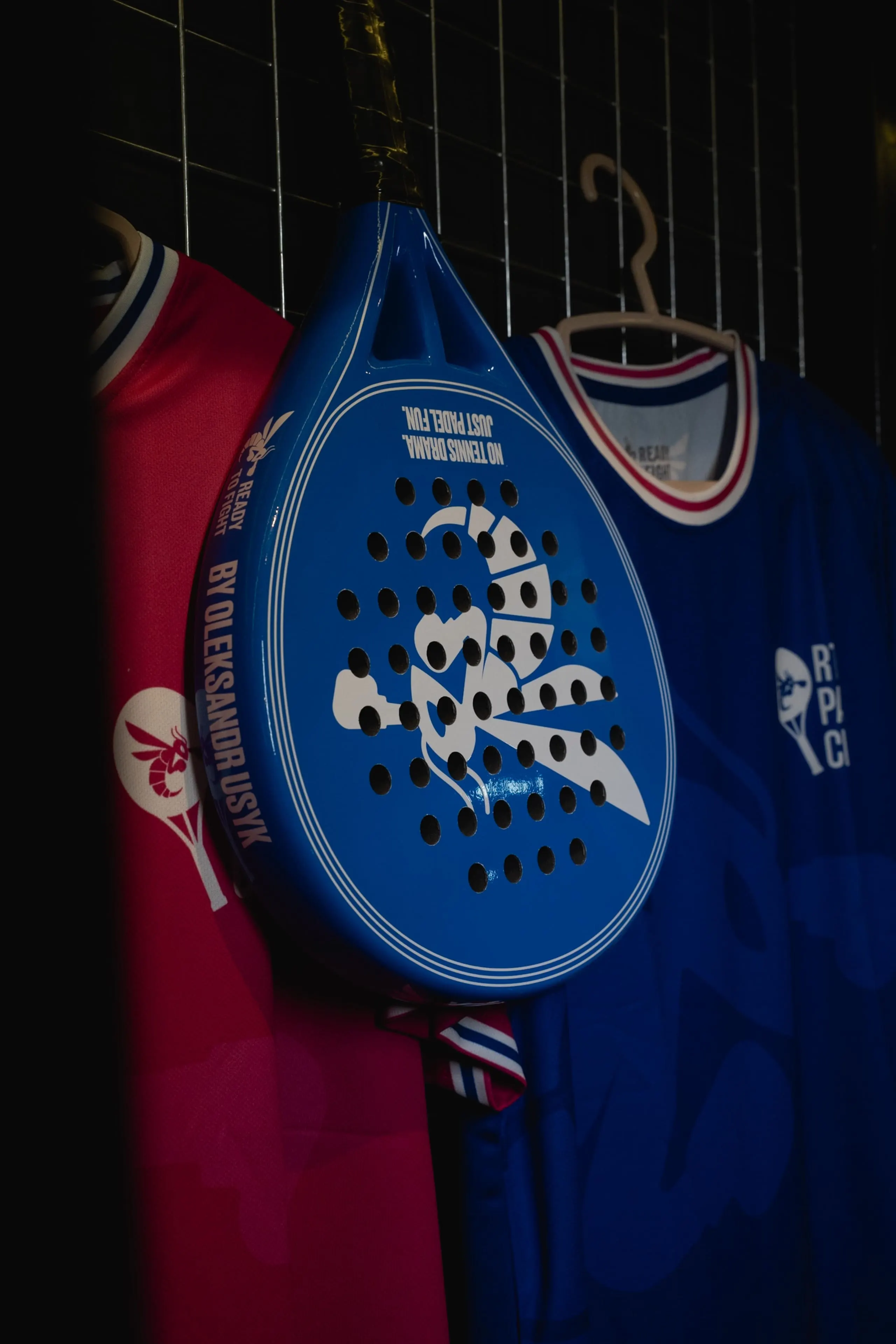 A signed padel racket mounted on the club wall