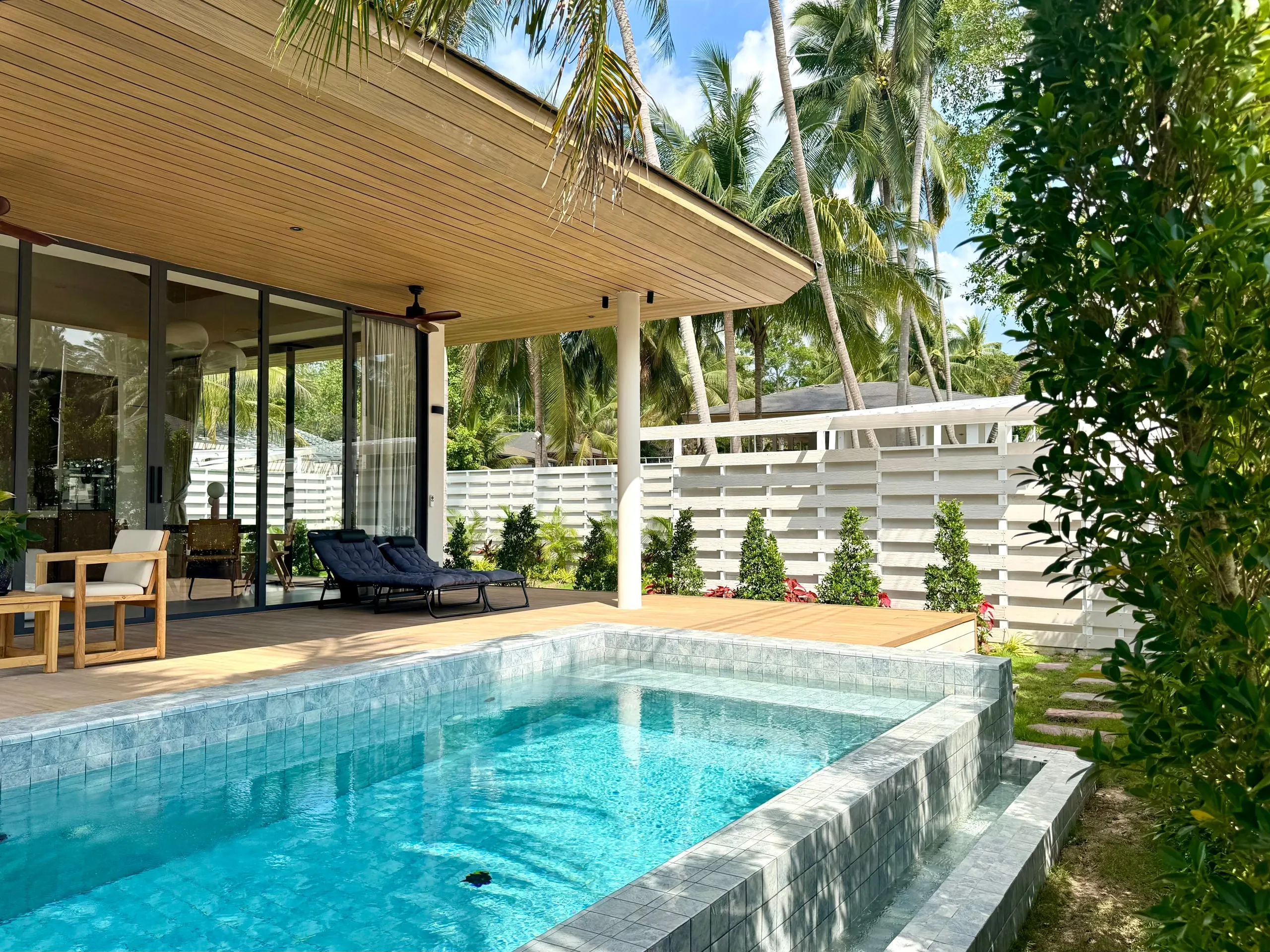 Villa I — corner pool with a raised stone edge among coconut palms